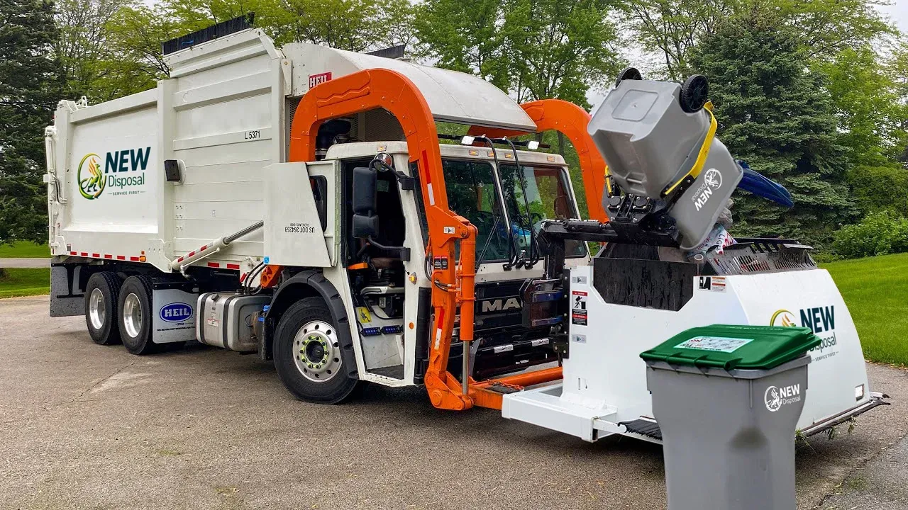 A NEW Disposal Curotto-Can truck lifting a residential bin curbside in Colorado Springs