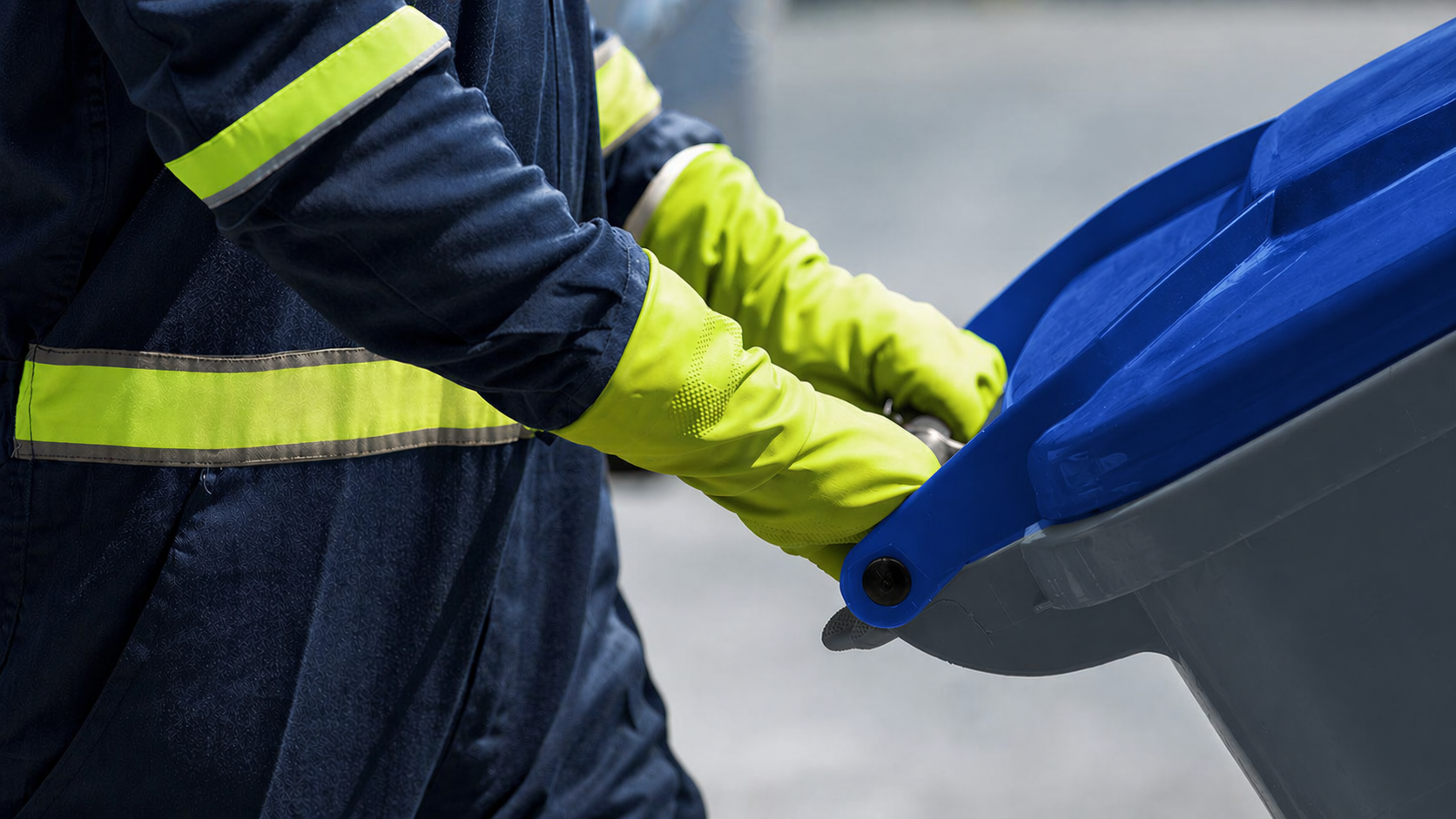 A NEW Disposal worker in high-visibility safety gear pushing a residential cart.